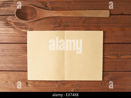 Cucchiaio di legno accanto al libro di ricette Foto Stock