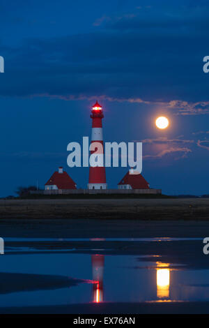 Faro Westerheversand di notte con la luna piena a Westerhever, il Wadden Sea National Park, Nord Frisia, Germania Foto Stock