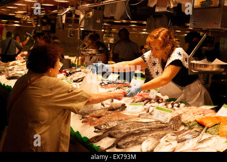 Un locale di donna di Barcellona l'acquisto di pesce al mercato del pesce in stallo, il mercato della Boqueria, Las Ramblas, Barcelona Spagna Europa Foto Stock