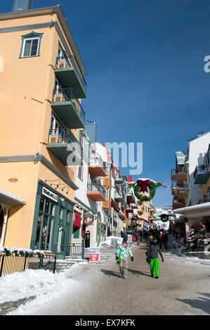 Gli appassionati di snowboard a camminare in una strada di Mt Tremblant resort, provincia del Québec in Canada. Foto Stock