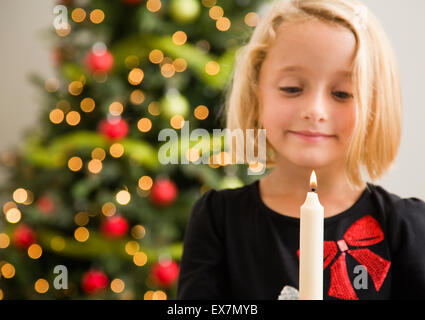 La ragazza (6-7) con il candelabro nella parte anteriore dell albero di Natale Foto Stock