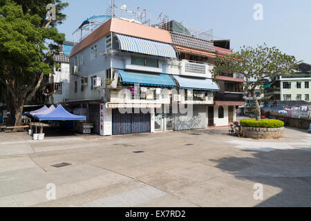 Hong Kong, Hong Kong - 19 novembre 2014:una piccola piazza con un tipico blocco alloggiamento su Cheung Chau Isola, Hong Kong. Cheun Foto Stock