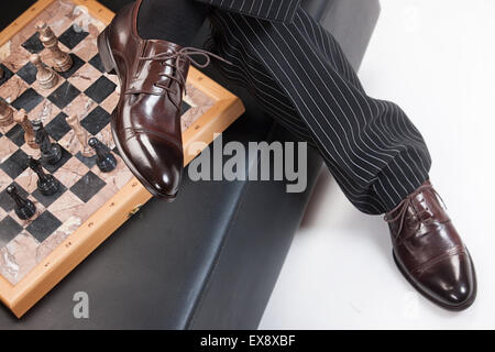 Uomo uomini persone Pantaloni Pantaloni a scacchi scacchi scacchi uomo-uomini studio gioco di sfondo isolato poltrona mobili per sedersi Foto Stock