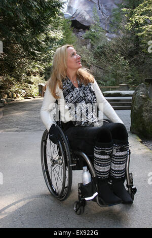 Una donna su una sedia a rotelle ad esplorare una cascata park Foto Stock