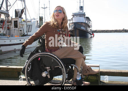 Donna che utilizza una sedia a rotelle su un molo sul fiume Fraser Foto Stock