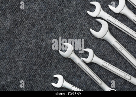 Chiavi di metallo in una fila sul tappeto grigio Foto Stock