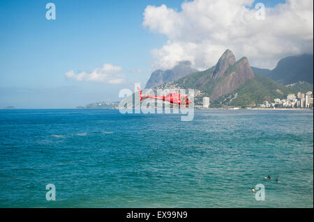 RIO DE JANEIRO - MARZO 22, 2015: Rosso bagnino brasiliano bombeiros elicottero pattuglia le spiagge. Foto Stock