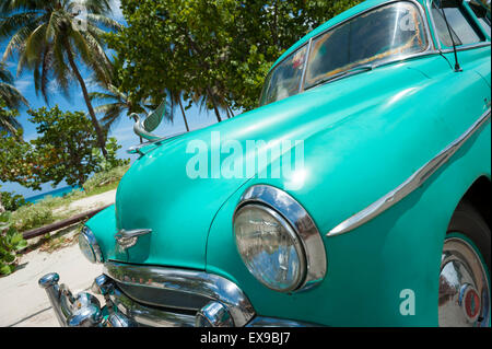 VARADERO, CUBA - Giugno 07, 2011: Classica vettura americana sta parcheggiata di fronte palme sulla strada vicino alla spiaggia. Foto Stock