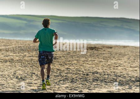 Un runner su Crantock Beach in Newquay, Cornwall. Foto Stock