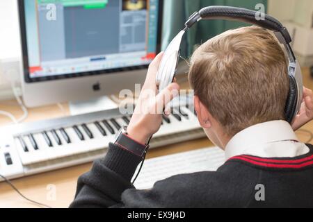 Scuola gli studenti in uniforme, utilizzando un software musicale e le apparecchiature nella lezione Foto Stock