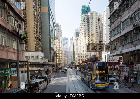 Cina, Hong Kong, passeggero guida bus tram del passato le vie lungo la trafficata strada nel quartiere centrale sul giorno di inverno Foto Stock