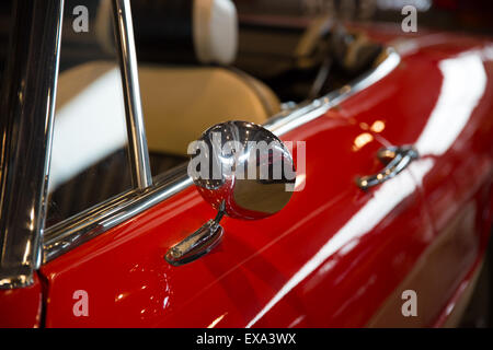 Chrome specchietto retrovisore di un automobile rossa Foto Stock