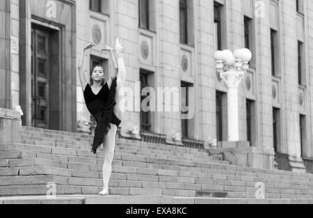 Ragazza ballerina flats permanente sulla tiptoes sulla strada Foto Stock