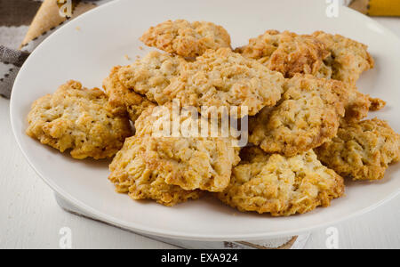 Appena sfornato biscotti di farina di avena su piastra bianca. Dof poco profondo. Foto Stock