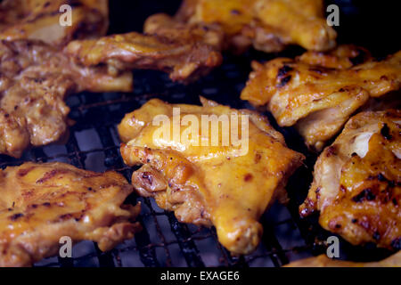 Grigliata di cosce di pollo sulla griglia fiammeggianti Foto Stock