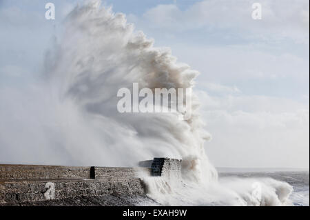 Onde infrangersi contro la parete del porto a Porthcawl, Bridgend, Wales, Regno Unito, Europa Foto Stock