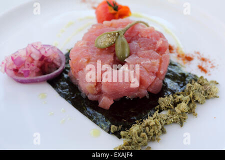 Red tartare di tonno con olio oilive, una figura e la cipolla è servita a Monopoli, Puglia, Italia, Europa Foto Stock