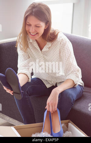 Donna ammirando le nuove scarpe acquistati online Foto Stock