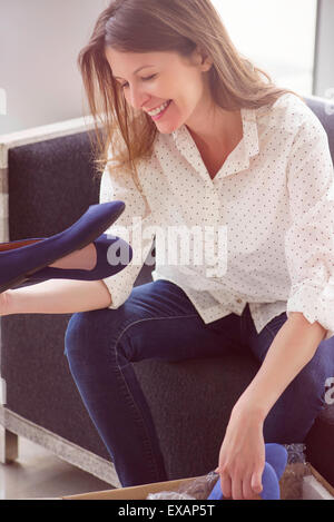 Donna disimballaggio scatola di scarpe nuove Foto Stock