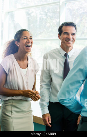 I soci dell'azienda avente illuminante momento insieme in ufficio Foto Stock