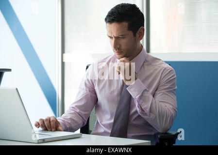 Uomo d affari con computer portatile in ufficio Foto Stock