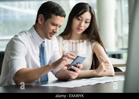 Officer lavoratore mostra collega lo smartphone Foto Stock