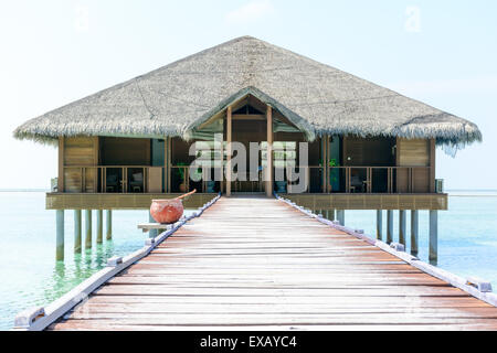 Overwater hut e jetty in un resort delle Maldive Foto Stock