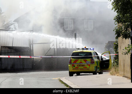 Croydon, Surrey venerdì 10 luglio 2015 Quattro motori Fire e una ventina di vigili del fuoco sono stati chiamati per un incendio al costruttore cantiere sulla corsia di fabbrica a Croydon questo pomeriggio il fuoco ha riguardato circa due tonnellate di rifiuti sfusi e una bombola di butano che equipaggi raffreddato. Station Manager Sally Harper che era presso la scena ha detto: "Il fuoco è stata ben sviluppata quando siamo arrivati e i nostri equipaggi hanno lavorato duramente per ottenere rapidamente sotto controllo. Grazie ai loro sforzi, il fuoco era limitata alla fase di cantiere, sebbene noi evacuata una casa nelle vicinanze proprio come una precauzione. Credito: Jason Kay/Alamy Live News Foto Stock