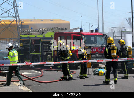 Croydon, Surrey venerdì 10 luglio 2015 Quattro motori Fire e una ventina di vigili del fuoco sono stati chiamati per un incendio al costruttore cantiere sulla corsia di fabbrica a Croydon questo pomeriggio il fuoco ha riguardato circa due tonnellate di rifiuti sfusi e una bombola di butano che equipaggi raffreddato. Station Manager Sally Harper che era presso la scena ha detto: "Il fuoco è stata ben sviluppata quando siamo arrivati e i nostri equipaggi hanno lavorato duramente per ottenere rapidamente sotto controllo. Grazie ai loro sforzi, il fuoco era limitata alla fase di cantiere, sebbene noi evacuata una casa nelle vicinanze proprio come una precauzione. Credito: Jason Kay/Alamy Live News Foto Stock