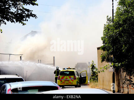 Croydon, Surrey venerdì 10 luglio 2015 Quattro motori Fire e una ventina di vigili del fuoco sono stati chiamati per un incendio al costruttore cantiere sulla corsia di fabbrica a Croydon questo pomeriggio il fuoco ha riguardato circa due tonnellate di rifiuti sfusi e una bombola di butano che equipaggi raffreddato. Station Manager Sally Harper che era presso la scena ha detto: "Il fuoco è stata ben sviluppata quando siamo arrivati e i nostri equipaggi hanno lavorato duramente per ottenere rapidamente sotto controllo. Grazie ai loro sforzi, il fuoco era limitata alla fase di cantiere, sebbene noi evacuata una casa nelle vicinanze proprio come una precauzione. Credito: Jason Kay/Alamy Live News Foto Stock