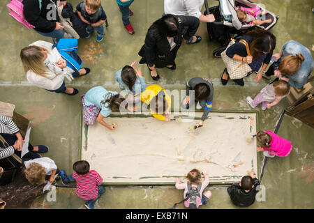 Glasgow, Scotland, Regno Unito - 10 Luglio 2015: Istruzione nella shopping mall. Divertenti attività per i bambini durante le vacanze scolastiche estive: i bambini in un mondo di loro come loro scavare uno scheletro di dinosauro a Intu Braehead Kid's Club. Il club è gratuita e aperta 11am - 5pm fino al giorno il 19 luglio a Intu Braehead shopping centre, Glasgow Credit: kayrtravel/Alamy Live News Foto Stock