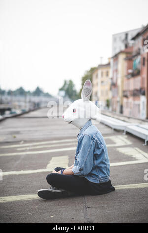 Maschera di coniglio giovane bello barbuto hipster uomo in città Foto Stock