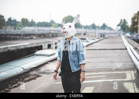 Maschera di coniglio giovane bello barbuto hipster uomo in città Foto Stock