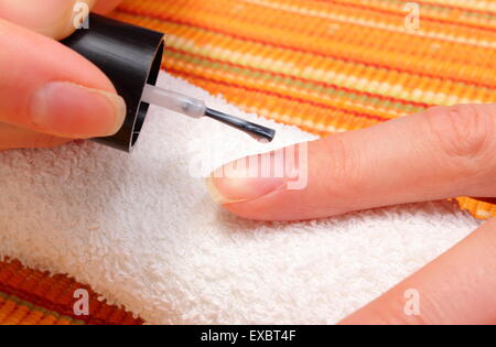 Donna rosa l'applicazione di smalto per unghie, unghie curati di donna su un panno morbido, la cura delle unghie Foto Stock