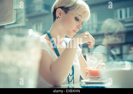 Giovane e bella bionda capelli corti hipster donna presso il cafe Foto Stock