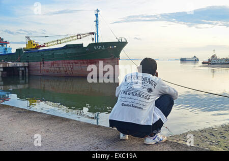 Un uomo godendo la vista del porto Foto Stock