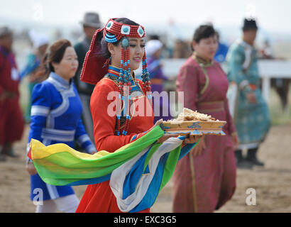 Baotou, la Cina della Mongolia Interna Regione Autonoma. 11 Luglio, 2015. Una ragazza di mongola gruppo etnico mostra cibo tradizionale al terzo nomade Turismo Culturale Festival a Darhan Muminggan United Banner di Baotou, nel nord della Cina di Mongolia Interna Regione Autonoma, luglio 11, 2015. Il festival di questo anno consiste di due sessioni stagionali, l'estate/autunno sessione a partire dal 11 luglio e l'inverno/primavera sessione a partire dal 12 dicembre. Credito: Lian Zhen/Xinhua/Alamy Live News Foto Stock