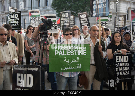 Londra, UK, 10 Luglio 2015 : Centinaia di palestinesi sostenitori provenienti da tutta la contea di tenere un ricordo di Gaza è morto un anno. Veglia per la Striscia di Gaza i nomi di tutti gli uomini, le donne e i bambini morti è la lettura e la posa di fiori al di fuori di Downing Street, Londra. Foto di vedere Li/Alamy Live News Foto Stock