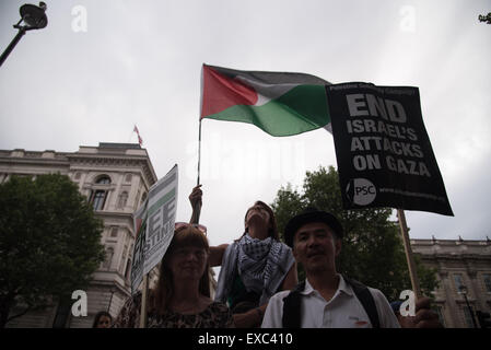 Londra, UK, 10 Luglio 2015 : Centinaia di palestinesi sostenitori provenienti da tutta la contea di tenere un ricordo di Gaza è morto un anno. Veglia per la Striscia di Gaza i nomi di tutti gli uomini, le donne e i bambini morti è la lettura e la posa di fiori al di fuori di Downing Street, Londra. Foto di vedere Li/Alamy Live News Foto Stock