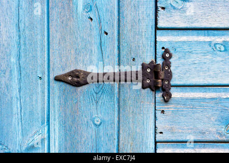 Una cerniera di metallo su un blu porta in legno Foto Stock