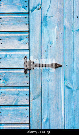 Una cerniera di metallo su un blu porta in legno Foto Stock