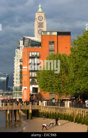 Le persone che giocano su un fiume Tamigi spiaggia vicino la Oxo Tower & Gabriel's Wharf, Southbank Londra, Inghilterra, Regno Unito. Foto Stock