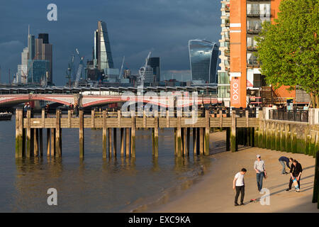 Le persone che giocano su un fiume Tamigi spiaggia vicino la Oxo Tower & Gabriel's Wharf, Southbank Londra, Inghilterra, Regno Unito. Foto Stock