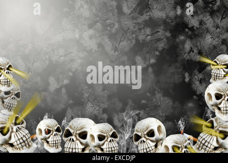 Strati di teschi umani con le sigarette accese su sfondo a trama. Foto Stock