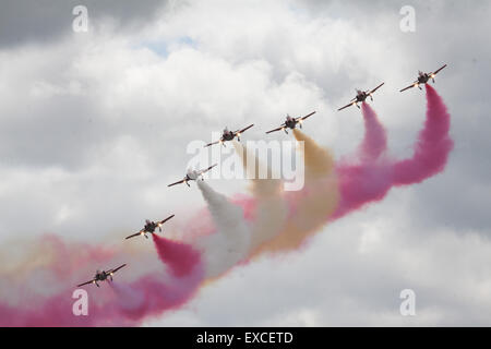 Yeovilton International Air giorno, Ilchester, Somerset, Regno Unito. 11 Luglio, 2015. La PATRULLA AGUILA la spagnola Air Force aerobatic team di dimostrazione a Yeovilton International Air giorno Il Team FLY sette Casa Aviojet formatori ed è finita lì con display rosso giallo Giallo display fumo battenti la loro bandiera nazionale Credito: David Billinge/Alamy Live News Foto Stock