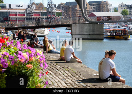 Persone rilassarsi e godersi il sole presso il porto di Bristol, Regno Unito Foto Stock