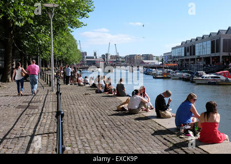 Persone rilassarsi e godersi il sole presso il porto di Bristol, Regno Unito Foto Stock