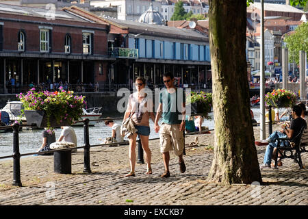 Persone rilassarsi e godersi il sole presso il porto di Bristol, Regno Unito Foto Stock