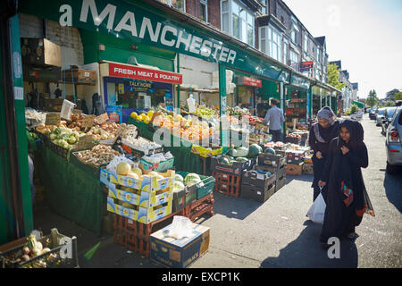 MANCHESTER Whalley area dell'intervallo i negozi di Clarendon Rd frutta supermercato mondo asiatico alimenti commercianti di strada indiano communi pakistan Foto Stock