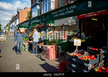 MANCHESTER Whalley area dell'intervallo i negozi di Clarendon Rd frutta supermercato mondo asiatico alimenti commercianti di strada indiano communi pakistan Foto Stock